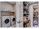 Well-lit laundry room with a washer, dryer, shelving and door leading to a full pantry in the home at 6 Lilla Rosa St, Henderson, NV 89011