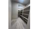 Walk-in pantry with ample shelving for organized storage, complete with tile flooring and neutral walls at 6 Lilla Rosa St, Henderson, NV 89011