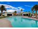 Luxury pool with lounge chairs set on a backdrop of residential buildings and palm trees at 6 Lilla Rosa St, Henderson, NV 89011