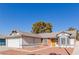 Single-story house exterior featuring a two-car garage and manicured lawn at 6200 Budnick Cir, Las Vegas, NV 89130