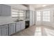 Well-lit kitchen with gray cabinets, double sink, and vinyl flooring at 6200 Budnick Cir, Las Vegas, NV 89130