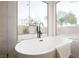 Enjoy the view from the large soaking tub in this bathroom with a matte black faucet and serene outdoor views at 6304 Tanzanite Ave, Las Vegas, NV 89130