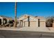 Beige one-story home featuring three-car garage, desert landscaping, and tile roof at 6304 Tanzanite Ave, Las Vegas, NV 89130