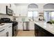 Bright kitchen with white cabinetry, island with bar stool seating, and modern stainless steel appliances at 6304 Tanzanite Ave, Las Vegas, NV 89130