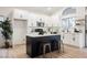 Bright kitchen with white cabinetry, island with bar stool seating, and modern stainless steel appliances at 6304 Tanzanite Ave, Las Vegas, NV 89130