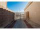 Side entrance with decorative metal gate, gravel, and brick walkway at 6304 Tanzanite Ave, Las Vegas, NV 89130