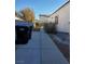 Side yard with a concrete pathway and trash bins at 637 Bay Bridge Dr, North Las Vegas, NV 89032