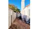 Narrow side yard with a block wall and a small palm tree at 637 Bay Bridge Dr, North Las Vegas, NV 89032