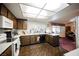 Galley style kitchen with wood cabinets, white appliances, and tile flooring at 6513 Hyde Ave, Las Vegas, NV 89107