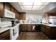 Galley style kitchen with wood cabinets, white appliances, and tile flooring at 6513 Hyde Ave, Las Vegas, NV 89107