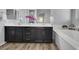 Bathroom featuring double sinks with dark cabinets, white countertops, and a soaking tub at 6692 Radiant Red Ave, Las Vegas, NV 89130