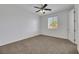 Carpeted bedroom featuring a ceiling fan and view from a window at 6692 Radiant Red Ave, Las Vegas, NV 89130