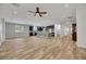 Open-concept kitchen and living area with dark cabinets, island seating, and wood-look flooring at 6692 Radiant Red Ave, Las Vegas, NV 89130