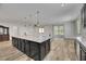 A kitchen island with dark cabinets, a marble countertop, and modern appliances at 6692 Radiant Red Ave, Las Vegas, NV 89130