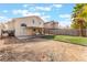 Large backyard featuring artificial turf, a block fence, and a covered patio at 6712 Painted Canyon Ct, Las Vegas, NV 89130