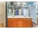 Bathroom featuring double sink vanity, large mirror, and a shower-tub combo with glass doors at 6712 Painted Canyon Ct, Las Vegas, NV 89130