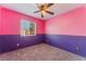 Bright bedroom with a ceiling fan, a large window, and purple and pink color scheme at 6712 Painted Canyon Ct, Las Vegas, NV 89130