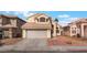 Two-story home with tan exterior, tile roof, two-car garage and desert landscaping at 6712 Painted Canyon Ct, Las Vegas, NV 89130