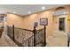 Upstairs hallway with an open staircase and framed Gathering photos at 685 Sea Star St, Henderson, NV 89002