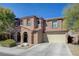 Two story house with beige exterior, attached garage, and landscaping at 7182 Hood River Ave, Las Vegas, NV 89179