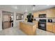 Kitchen with island, wood cabinets, and black appliances at 7182 Hood River Ave, Las Vegas, NV 89179