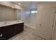 Bathroom with double vanity, dark brown cabinets, and a large soaking tub at 7672 Lush Oasis Ave, Las Vegas, NV 89113