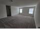 Large main bedroom with gray carpet and two windows with blinds at 7672 Lush Oasis Ave, Las Vegas, NV 89113