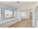 A luxurious bathroom with soaking tub, double mirrored closet doors and large windows at 7900 Holly Knoll Ave, Las Vegas, NV 89129