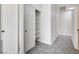 Hallway with gray carpet and white walls features closet with shelving for ample storage at 7900 Holly Knoll Ave, Las Vegas, NV 89129