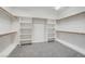 Spacious walk-in closet with carpeted floor, shelving, and hanging rods for optimal storage at 7900 Holly Knoll Ave, Las Vegas, NV 89129