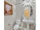 Elegant powder room with pedestal sink, toilet, and decorative mirror at 900 Mckinley View Ave, Henderson, NV 89012