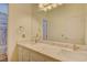 Bathroom vanity features dual sinks, quartz countertop, a large mirror and modern fixtures at 1140 Woodcastle St, Henderson, NV 89052