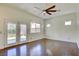 Bedroom features wood floors, a ceiling fan, French doors and windows for natural light at 1140 Woodcastle St, Henderson, NV 89052