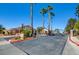 Gated community entrance featuring lush landscaping and tall palm trees, offering security and curb appeal at 1140 Woodcastle St, Henderson, NV 89052
