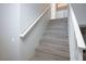 Modern stairs with wood-look laminate flooring and white railing at 1664 Britannia Ave, Henderson, NV 89014