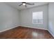 Empty bedroom featuring hardwood floors, ceiling fan, and a bright window at 2204 Twin Falls Dr, Henderson, NV 89044