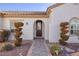 Inviting front entrance featuring a decorative glass door, a brick walkway, and sculpted bushes at 2204 Twin Falls Dr, Henderson, NV 89044