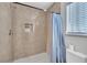 Shower with light beige marble tile and a blue shower curtain at 3257 Coral Harbor Dr, Las Vegas, NV 89117