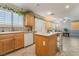 Open kitchen with island, views to living area, and wood cabinets at 5695 Merced St, Las Vegas, NV 89148