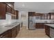 Modern kitchen featuring dark wood cabinets, stainless steel appliances, and granite countertops at 6336 San Gagano Ave, Las Vegas, NV 89131