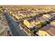 Expansive aerial view of a neighborhood featuring homes, streets, and a distant city skyline at the horizon at 6595 Creekside Cellars Ct, Las Vegas, NV 89139