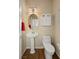 Cozy bathroom with a pedestal sink, decorative wallpaper and a decorative medicine cabinet above the toilet at 6595 Creekside Cellars Ct, Las Vegas, NV 89139
