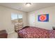 Bedroom showcasing a patterned bedspread, dresser, and a view overlooking the neighborhood at 6595 Creekside Cellars Ct, Las Vegas, NV 89139