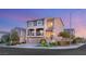 Two-story home featuring a three-car garage, balcony, and stone accents, set against a twilight sky at 6595 Creekside Cellars Ct, Las Vegas, NV 89139