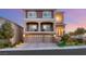 Elegant two-story home with stone accents, balconies, and a three-car garage at dusk at 6595 Creekside Cellars Ct, Las Vegas, NV 89139