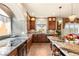 Elegant kitchen features a center island, granite countertops, wood cabinets and designer lighting at 6595 Creekside Cellars Ct, Las Vegas, NV 89139