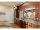 Beautiful kitchen featuring granite countertops, stainless steel appliances, custom backsplash and archway window at 6595 Creekside Cellars Ct, Las Vegas, NV 89139