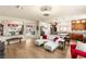 Bright living room featuring a modern couch, wood floors, and an open layout into the dining and kitchen areas at 6595 Creekside Cellars Ct, Las Vegas, NV 89139