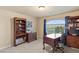 Home office featuring a large window, a desk, built-in shelving, and a chest of drawers at 6595 Creekside Cellars Ct, Las Vegas, NV 89139
