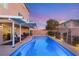 Beautiful pool with a covered patio, string lights, and lush landscaping, perfect for evening relaxation at 6595 Creekside Cellars Ct, Las Vegas, NV 89139